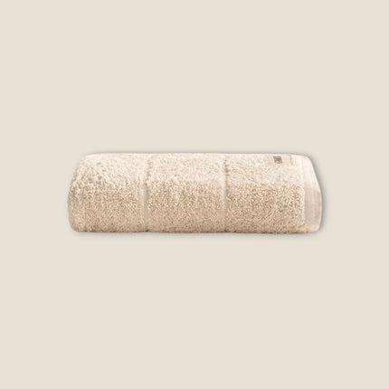 Madhome.ro beige cotton bath towel with a plush, absorbent texture and reinforced hem detail.