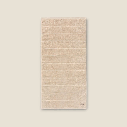 Madhome.ro beige cotton bath towel with a soft, absorbent texture and elegant hem detail