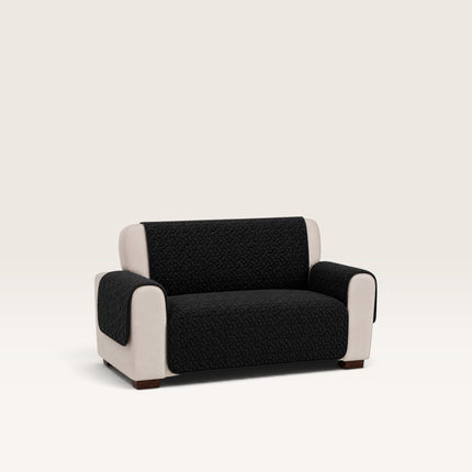 Madhome.ro black quilted sofa cover for a 2-seater couch, featuring a soft microfiber texture and armrest protection.