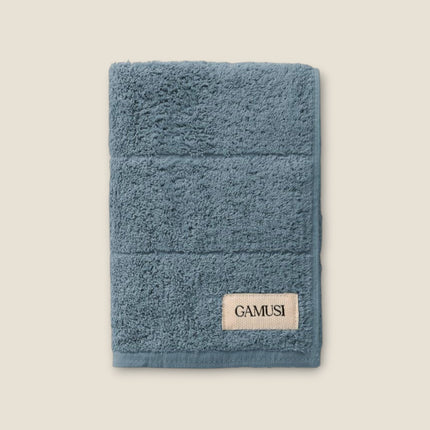 Madhome.ro blue cotton bath towel with a textured surface and a GAMUSI brand label