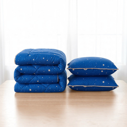 Madhome.ro blue quilted bedding set with a folded duvet and two pillows featuring a star pattern on a wooden table.