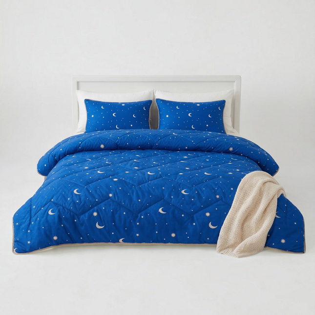 Madhome.ro blue quilted bedding set with moon and star pattern, including a duvet and two pillows on a white bed.