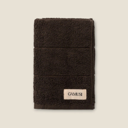 Madhome.ro dark brown cotton bath towel with a soft, plush texture and a branded label on a light background.