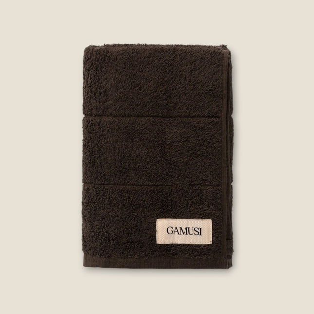 Madhome.ro dark brown cotton bath towel with a soft, plush texture and a branded label on a light background.