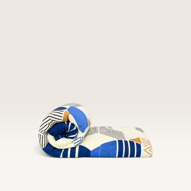 Madhome.ro quilted duvet with a modern sapphire blue geometric pattern on a light background, folded neatly.