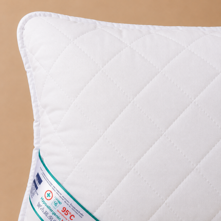 Madhome.ro HypoallergenicMed white quilted pillow with a 95°C washable label, showing detailed stitching texture.