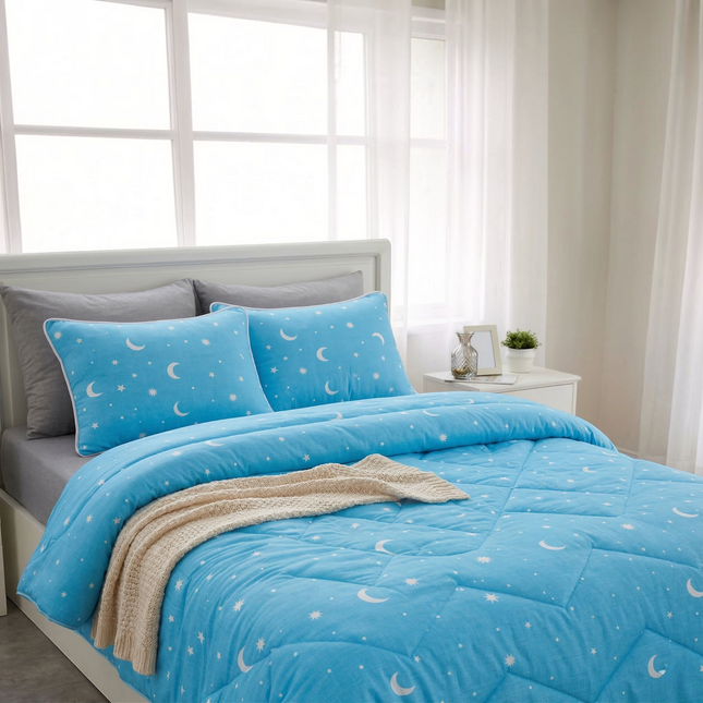 Madhome.ro light blue quilted bedding set with moon and star pattern, including a duvet and two pillows on a bed.