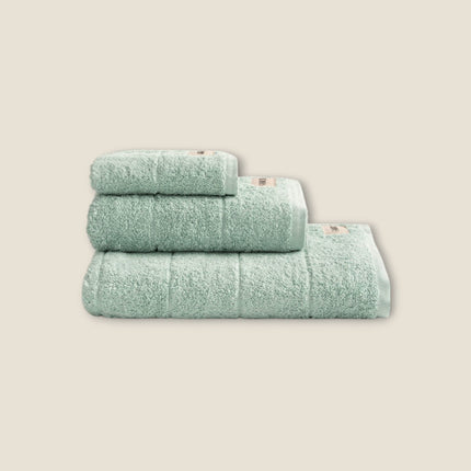 Madhome.ro set of three soft, mint green 100% cotton bath towels stacked neatly on a white background.