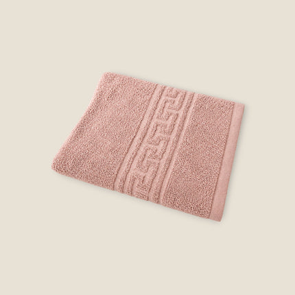 Madhome.ro pink cotton bath towel with a decorative Greek key border and textured absorbent fabric.