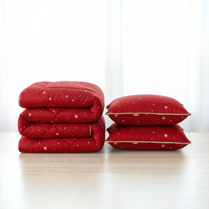 Madhome.ro red quilted spring duvet and two matching pillows with gold star patterns on a wooden surface