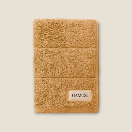 Madhome.ro soft tan cotton bath towel with a textured weave and branded label
