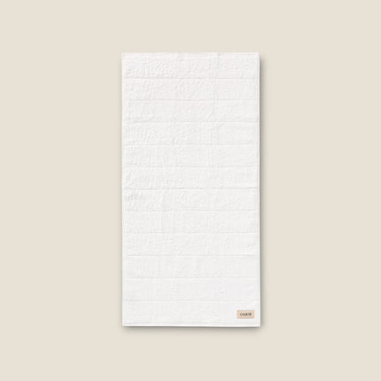 Madhome.ro white cotton bath towel with a soft, textured design and a small branded label on a neutral background