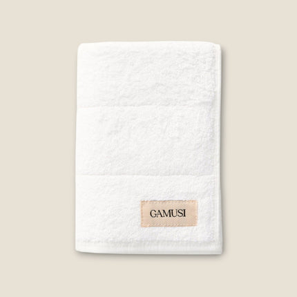 Madhome.ro white cotton bath towel with a textured surface and a branded label, soft and absorbent design.