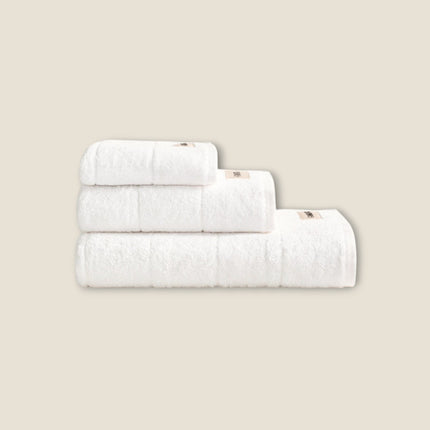 Madhome.ro set of three white fluffy cotton bath towels stacked neatly, featuring high-density absorbent fabric.